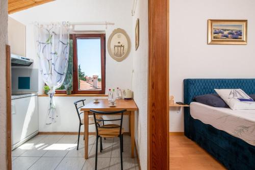 ein kleines Zimmer mit einem Tisch und einem Bett sowie einer kleinen Küche in der Unterkunft Casa Meazza-Apartman Nero in Medulin