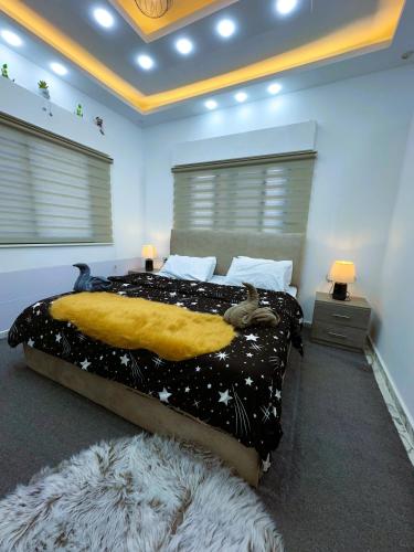a bedroom with a large bed with a yellow blanket at Jerash City View in Jerash