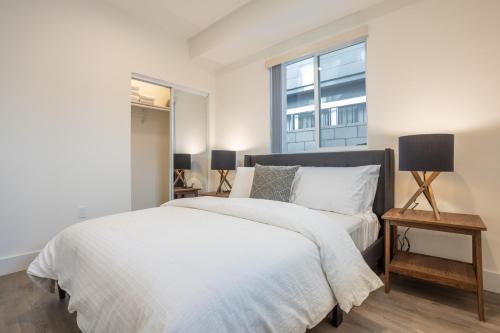 a white bedroom with a bed and a window at Modern Living by AvantStay DTLA Walk to Staples in Los Angeles