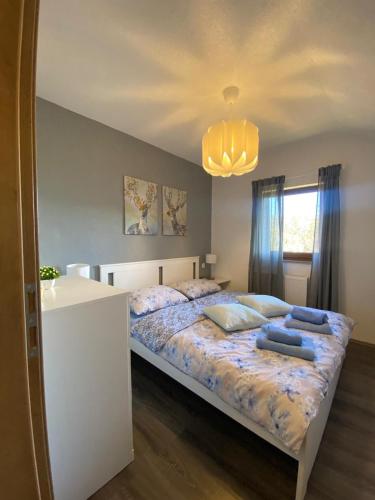 a bedroom with a bed with blue pillows on it at Apartman Kremen in Kuterevo