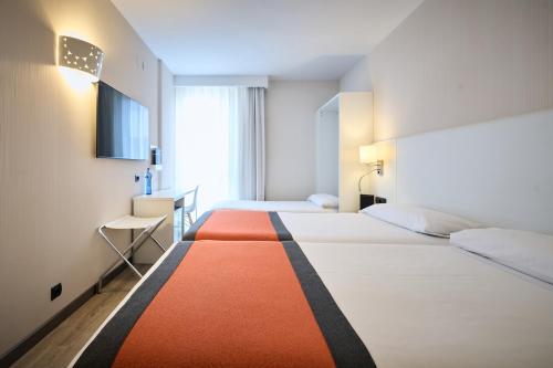 a hotel room with two beds with an orange and white rug at Catalonia Bristol in Sant Andreu de la Barca