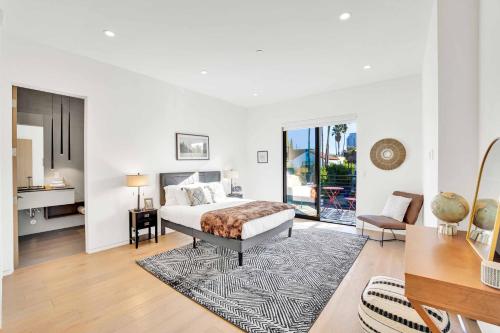 a white bedroom with a bed and a table and a desk at LA Villa by AvantStay Walk to The Grove LA in Los Angeles