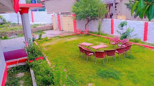 un patio con mesa y sillas en el césped en Zago Guest House, en Skardu