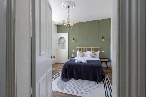 格拉斯哥的住宿－Spacious 3 Bedroom Home In Glasgow - Free Parking，一间卧室配有一张带蓝毯和吊灯的床。