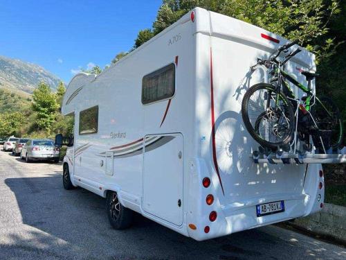 a white trailer with a bike on the back at Camper Rent motorhome Albanian in Tirana