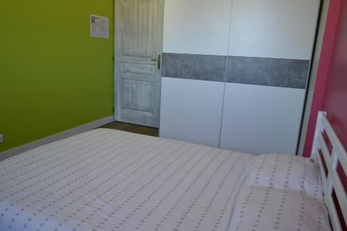 ein Schlafzimmer mit einem weißen Bett in einem grünen Zimmer in der Unterkunft Chambre cosy pour 2 personnes in Chef-Boutonne