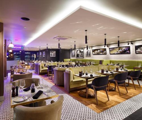 a restaurant with tables and chairs in a room at Holiday Inn Brentwood by IHG in Brentwood