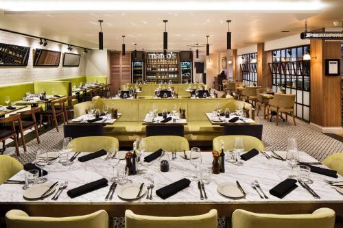 a dining room with tables and chairs and a restaurant at Holiday Inn Brentwood by IHG in Brentwood