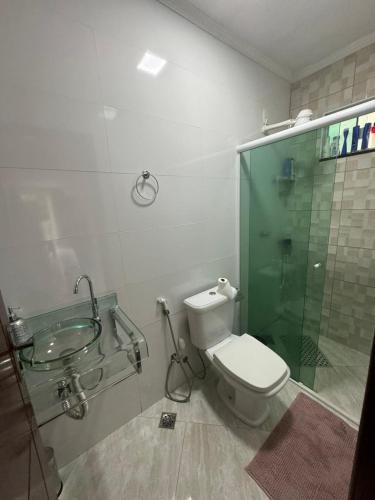 a bathroom with a glass shower and a toilet at Casa bosque in Papuda