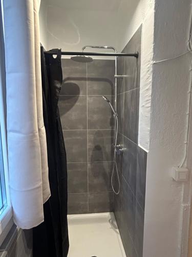 uma casa de banho com um chuveiro com uma cortina de chuveiro preta em Appartement cosy Place Paoli em Corte