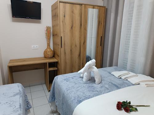 a room with a bed with a stuffed animal on it at Rooms Anastasia Paralia in Paralia Katerinis