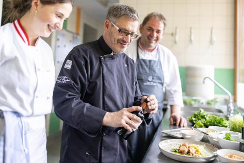 three chefs standing in a kitchen preparing food at Hotel Hochschober in Turracher Hohe