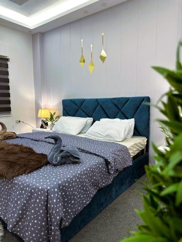 a bedroom with a blue bed with a blue headboard at Jerash City View in Jerash