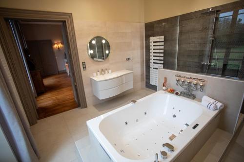 CHATEAU DE QUINCEY في Quincey: حمام كبير مع حوض ومغسلة