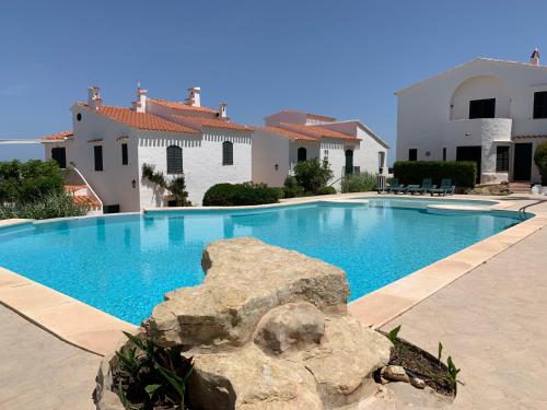 una grande piscina di fronte a una casa di Apartamento oportunidad en la playa a Son Parc