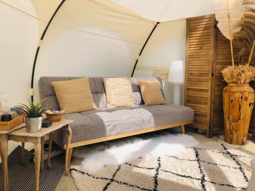a living room with a couch in a tent at Glamping -Logie Moonlight in Brakel