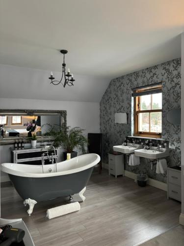 a bathroom with two sinks and a large tub at Ach-Na-Sidhe in Dores