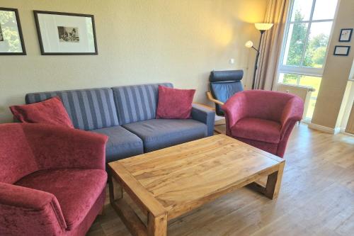 un soggiorno con divano, 2 sedie e tavolo di Seepark Sellin FeWo AG Whg 253 a Ostseebad Sellin