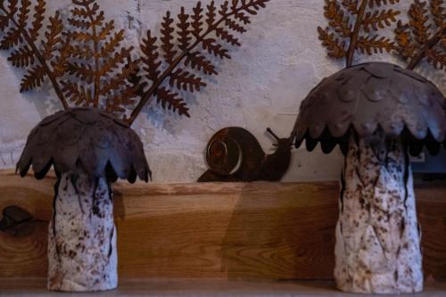 two mushrooms on a shelf with a snail at Urban Lofts in Melksham