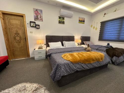 a bedroom with a bed with an orange blanket on it at Jerash City View in Jerash