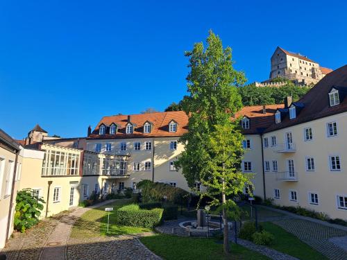 a group of buildings with a tree in the middle at Haus der Begegnung Heilig Geist in Burghausen