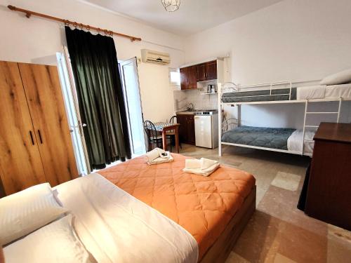 a bedroom with a bed and bunk beds in it at Eleni Apartments Sant George Beach in Agios Georgios