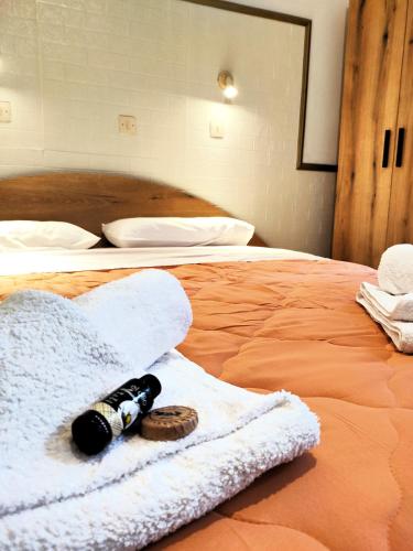 a white towel on a bed with a bottle on it at Eleni Apartments Sant George Beach in Agios Georgios