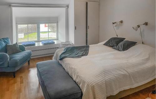 博里霍尔姆2 Bedroom Lovely Apartment In Borgholm的一间卧室，里面有一张床、一把椅子和一扇窗户