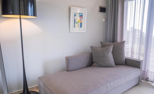 a couch in a room with a lamp and a window at Ktima Faki, Olympus Mountain Accommodation & Retreat in Litochoro