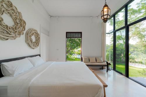 een slaapkamer met een groot bed en een groot raam bij Riverside Pool Villa - Nature Escape - Chiang Mai in Ban Don