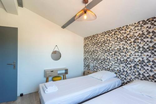 a bedroom with two beds and a brick wall at Chez Diane - Luxueuse Villa avec piscine et plage à proximité in La Grande-Motte