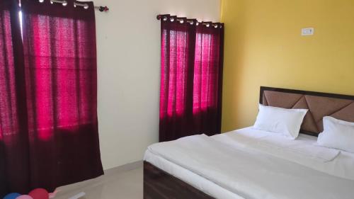 sypialnia z łóżkiem i czerwonymi zasłonami w obiekcie HOTEL MEERA w mieście Bettiah