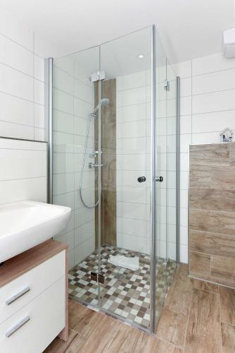 a shower with a glass door in a bathroom at Residenz Waterkant in Bensersiel