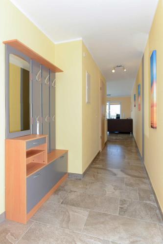 a hallway of an office with a desk and a mirror at Residenz Waterkant in Bensersiel
