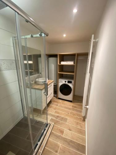 une salle de bain avec douche, lave-linge et lavabo dans l'établissement Duplex la parenthèse bretonne, à Auray