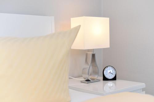 a lamp on a table with a clock on it at Residenz Waterkant in Bensersiel