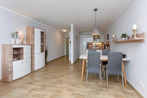 a kitchen and dining room with a table and chairs at Residenz Waterkant in Bensersiel