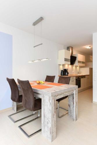a dining room with a wooden table and chairs at Residenz Waterkant in Bensersiel