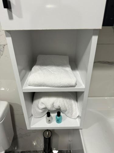 a white cabinet with towels and a bed in a bathroom at Gürtürkler Suit Otel in Muş