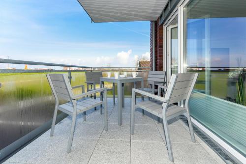 a patio with chairs and a table on a balcony at Residenz Waterkant in Bensersiel
