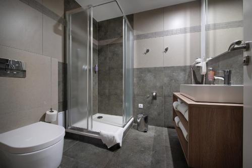 a bathroom with a shower and a toilet and a sink at Vysocina Design Apartments in Hlinsko