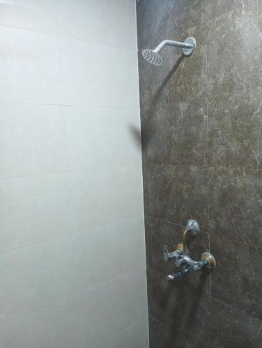 y baño con ducha con cabezal de ducha. en CozyStay, en Ghaziabad