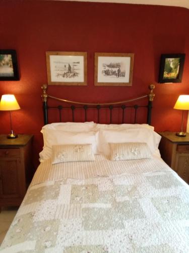 a bedroom with a large bed with red walls at Tanners Cottage in Cockermouth