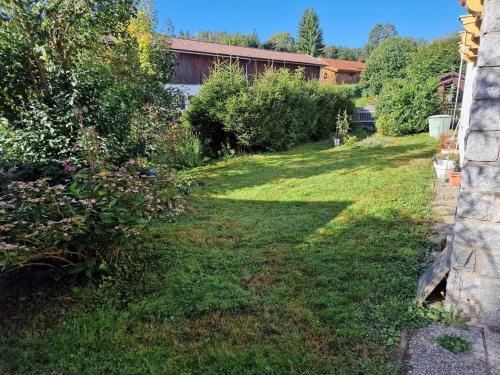 a yard with green grass and trees and a building at Bachoase Bischofsmais in Bischofsmais