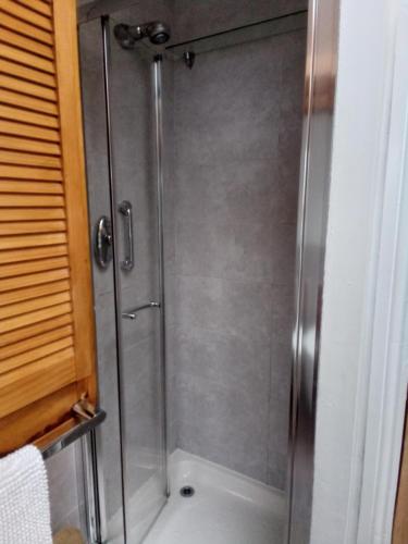 a shower with a glass door in a bathroom at Tanners Cottage in Cockermouth