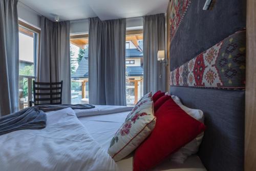 Un dormitorio con una cama con almohadas rojas. en Zakopane Jagnięcy Szczyt, en Zakopane