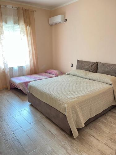 1 dormitorio con 2 camas y ventana en Casa Farinelli, en Campobello di Mazara