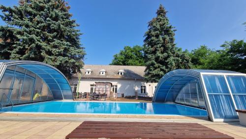 a swimming pool in front of a house at Aphrodite Hotel in Göd