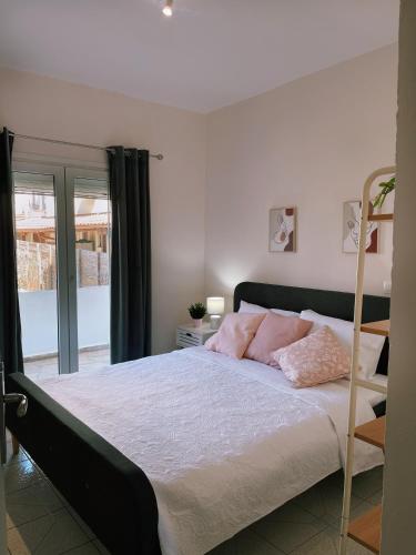 a bedroom with a bed with pink pillows on it at By the Sea Luxury Apartment in Nikiti