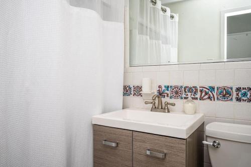 a bathroom with a sink and a toilet and a mirror at Atlanta Downtown! 1B Paid Onsite Parking! LM301 in Atlanta